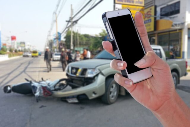 taking photos of motorcycle wreck after a collision with a car