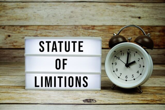 "Statute of Limitations" displayed on a lightbox beside an alarm clock, emphasizing critical filing deadlines.